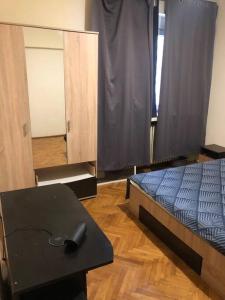 a bedroom with a bed and a table and a mirror at Amazing Apartments in Bucharest