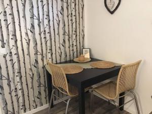 a black table with chairs in a room with a tree curtain at Moderne private Monteurs- und Ferienwohnung in Geesthacht