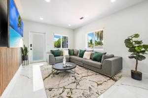a living room with a couch and a table at Modern Chic Retreat Pool Full amenities backyard L10 in Miami