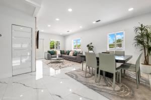 a dining room and living room with a table and chairs at Modern Chic Retreat Pool Full amenities backyard L10 in Miami