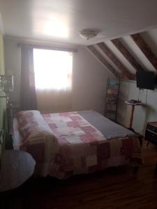 1 dormitorio con 1 cama con manta a cuadros en sleep easy 2, en Coquimbo