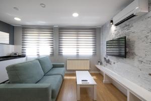 A television and/or entertainment centre at ALQUILAZ Apartamentos Turísticos