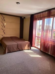 a bedroom with a bed and a large window at Iglika Bansko in Bansko