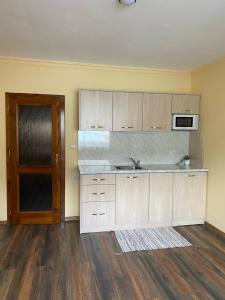 an empty kitchen with a sink and a microwave at Iglika Bansko in Bansko
