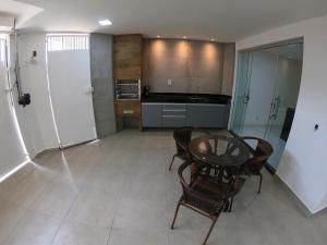 a kitchen with a table and chairs in a room at TH 101 - Flat com Banheira de Hidromassagem in Governador Valadares