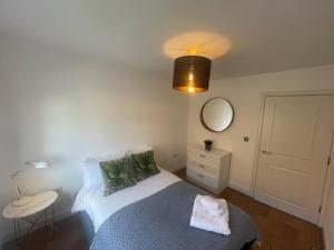 a small bedroom with a bed and a mirror at Scarborough - Stylish 2 Bedroom Flat on the Spectacular Esplanade in Scarborough