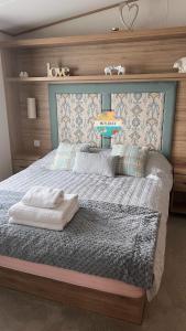 a bedroom with a large bed with alove sign on it at Field View - Martello Beach - Sylwia's Holiday Homes in Jaywick Sands