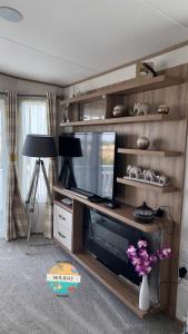 a living room with a flat screen tv in a entertainment center at Field View - Martello Beach - Sylwia's Holiday Homes in Jaywick Sands