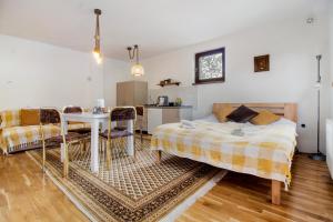 a bedroom with a bed and a table and chairs at Apartmani Jelenača prizemlje in Trnovo