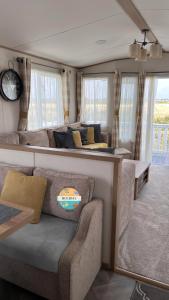 a living room with a couch and a table at Field View - Martello Beach - Sylwia's Holiday Homes in Jaywick Sands