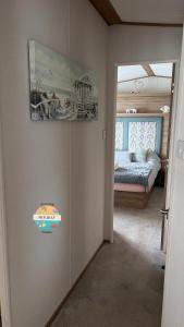 ein Schlafzimmer mit einem Bett und einem Bild an der Wand in der Unterkunft Field View - Martello Beach - Sylwia's Holiday Homes in Jaywick Sands