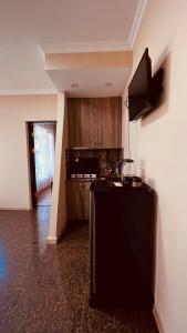 een keuken met een zwarte koelkast en houten kasten bij Natalia Guest House in Batoemi