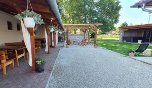 a patio with a wooden pergola and tables and chairs at Joy's apartman Molnári 