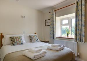 a bedroom with a bed with towels on it at Chapel Cottage in Hempstead