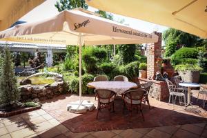 a table and chairs under an umbrella on a patio at Hotel Senator in Timişoara