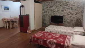 a living room with a room with a stone wall at Maison 1940 La Bethaz in Valgrisenche