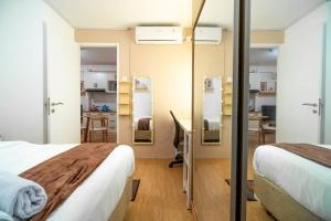 ジャカルタにあるElegance 2BR @ Bassura City East Jakarta /Netflixのベッド2台、デスク、キッチンが備わる客室です。 +32枚の写真