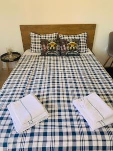 a bed with a blue and white checkered blanket at Studio Chalet 13, St John Park Bansko in Bansko