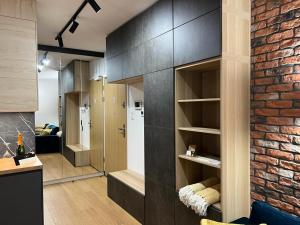 a living room with a brick wall and a kitchen at Modern Vero Apartments Yacht Park in Gdynia