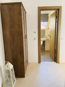 a bathroom with a large wooden door and a toilet at Studio Chalet 13, St John Park Bansko in Bansko
