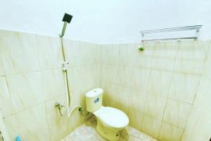 bagno con servizi igienici bianchi in camera di OYO 93052 Batodupi Guesthouse Syariah 