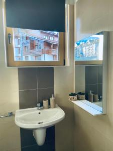 a bathroom with a white sink and a mirror at Studio Chalet 13, St John Park Bansko in Bansko