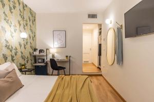 1 dormitorio con 1 cama y escritorio con silla en 94Rooms Vatican Guest House- Scipioni, en Roma