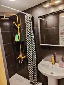 uma casa de banho com um lavatório e um chuveiro em Apartment hotels parking akaciju1 em Vilnius
