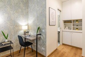 a room with a desk with a chair and a kitchen at 94Rooms Vatican Guest House- Scipioni in Rome