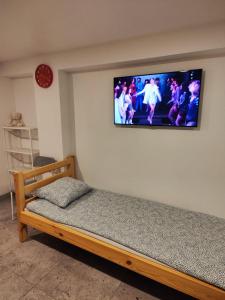 a bedroom with a bed with a television on the wall at Apartment hotels parking akaciju1 in Vilnius