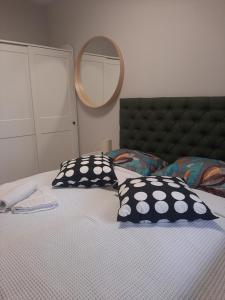 een slaapkamer met een bed met 2 kussens en een spiegel bij Blue Moon Bulevar in Sarajevo