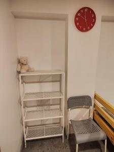a teddy bear sitting on a shelf next to a clock at Apartment hotels parking akaciju1 in Vilnius