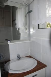 een witte badkamer met een wastafel en een raam bij Appartement Cosy au cœur de Saint Lary in Saint-Lary-Soulan