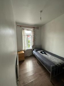 a bedroom with a bed in a room with a window at Affordable Private Rooms in Wembley in London