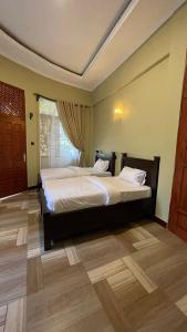a bedroom with two beds and a window at Skill forest lodge in Arusha
