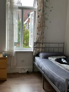 a bedroom with a bed in front of a window at Affordable Private Rooms in Wembley in London