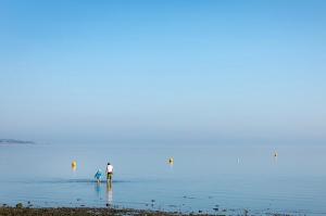 two people standing in the water at the beach at Staycay Luxury Caravan in Seasalter