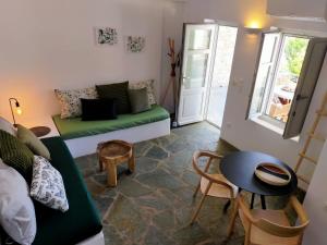 un soggiorno con un divano verde e un tavolo di Amorgos Elegant Houses, 6 Villas ad Amorgo