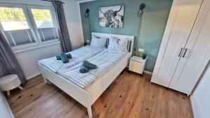 a bedroom with a white bed with blue towels on it at Ferienhaus Seeoase - 70qm - Kamin -Terrassen - Parkplatz - Badestelle fußläufig in Joachimsthal
