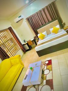 Posh Hotel and Suites Ikeja في إيكيجا: غرفة نوم بسرير واريكة وطاولة