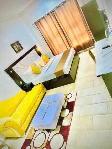 a view of a bedroom with two beds and a rug at Posh Hotel and Suites Ikeja in Ikeja