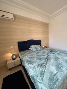 a bedroom with a bed and a wooden wall at cosy et spacieux, avec balcon in Ariana