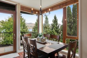 a dining room with a table and chairs and large windows at Chelan Resort Suites Coco Chelan 212 in Chelan