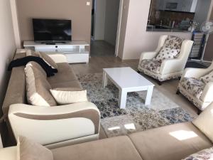 sala de estar con sofá, 2 sillas y TV en الكويت, 