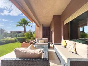 een patio met een bank en stoelen op een veranda bij Les Jardins Du Paradis 2. in Marrakesh