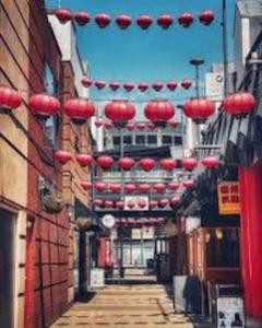 an alley with red lanterns hanging over a street at Luxury City Centre Apartment With Underground Parking in Birmingham
