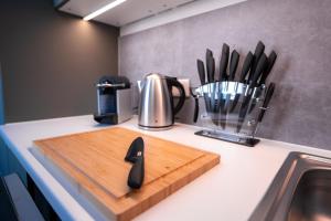 a kitchen counter with a cutting board and utensils at Design Apartment - Balkon - Induktionskochfeld - Zentral in Dresden