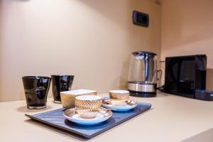 a tray with bowls and cups on top of a counter at Airport BEA Rooms in Azzano San Paolo