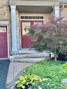 a house with a red door and a tree at Townhouse in Oakville in Oakville