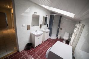 a bathroom with two sinks and a toilet and a mirror at Pokoje Jaśminowa in Lublin